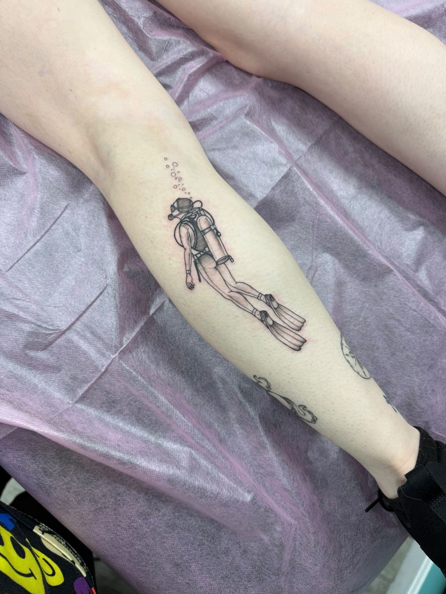 Scuba diver with bubbles on the calf — fine line tattoo by Aline at Diamond Mind Tattoo, Buzzards Bay