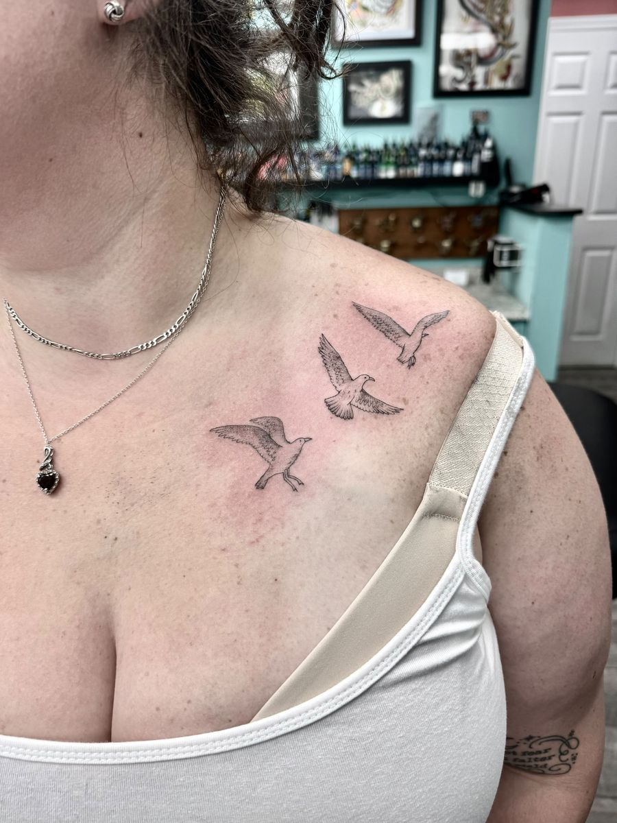 Three birds in flight across the collarbone — fine line tattoo by Aline at Diamond Mind Tattoo, Buzzards Bay