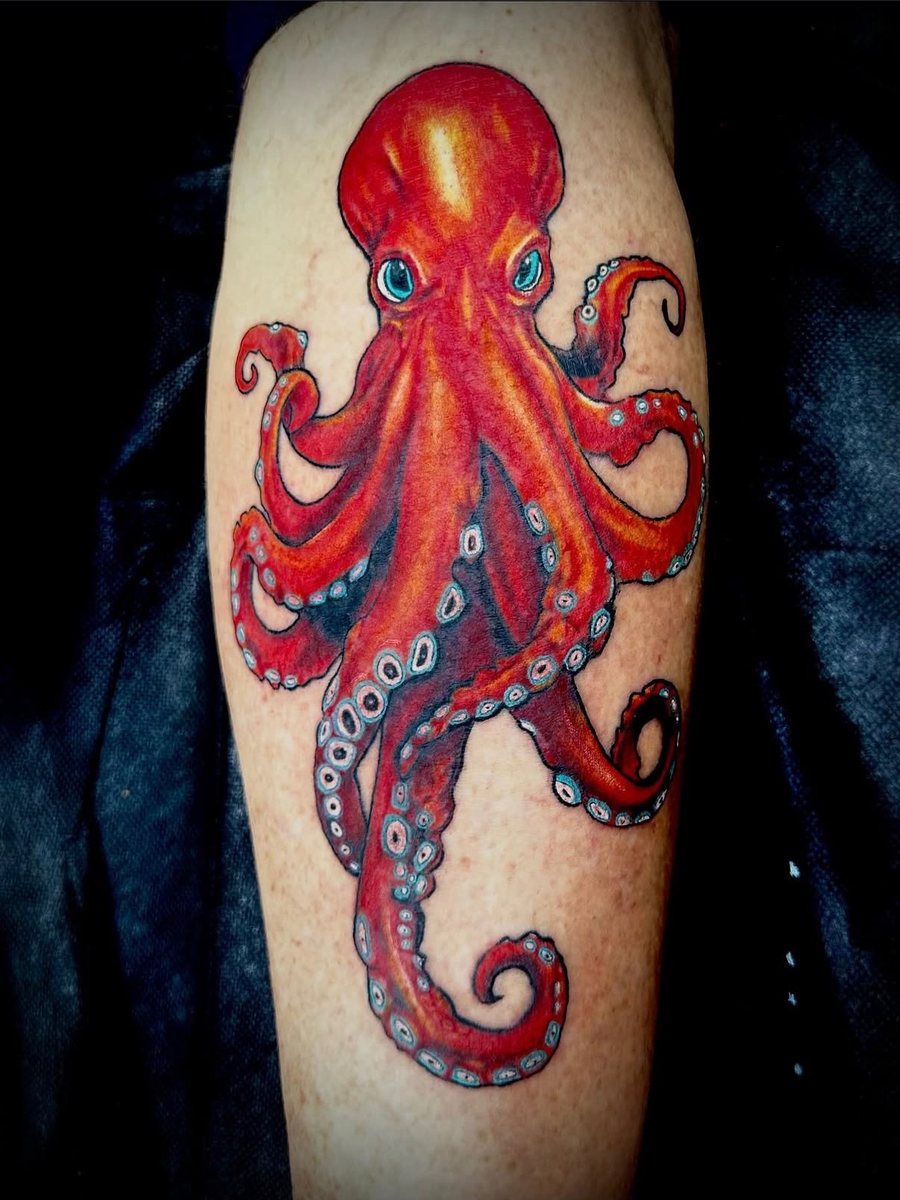 Red octopus with curling tentacles on the calf, color realism tattoo by Brendon at Diamond Mind Tattoo, Buzzards Bay