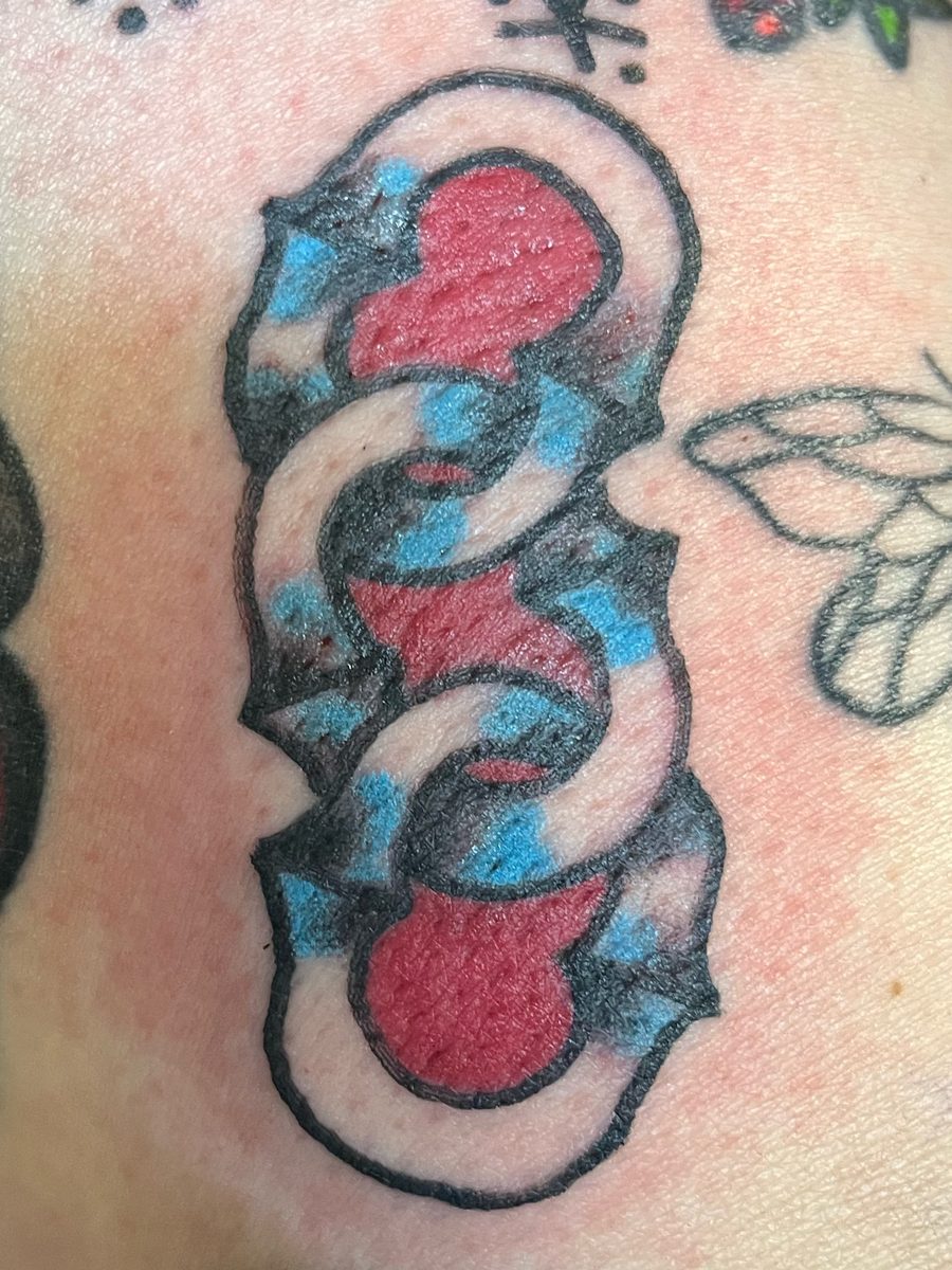 Chain links in red, blue and white on the leg, American Traditional tattoo by Chris at Diamond Mind Tattoo, Buzzards Bay