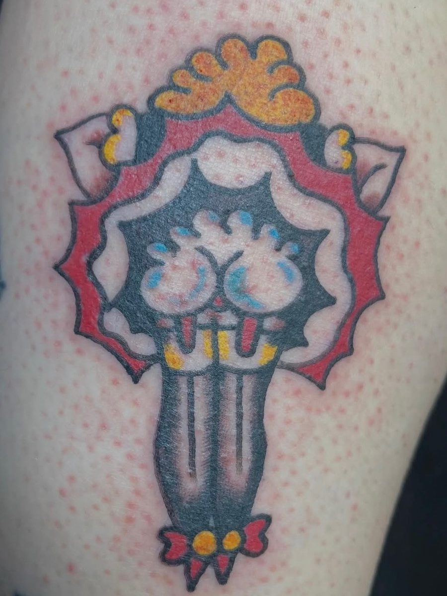 Pin-up style legs in black stockings with a red bow, inside a red scalloped frame on the thigh, American Traditional tattoo by Chris at Diamond Mind Tattoo, Buzzards Bay