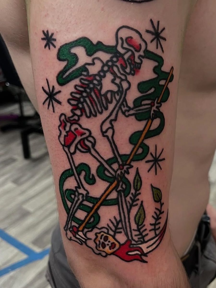 Skeleton with a green snake and a staff, stars around it and a flaming skull at its feet, on the upper arm, American Traditional tattoo by Chris at Diamond Mind Tattoo, Buzzards Bay